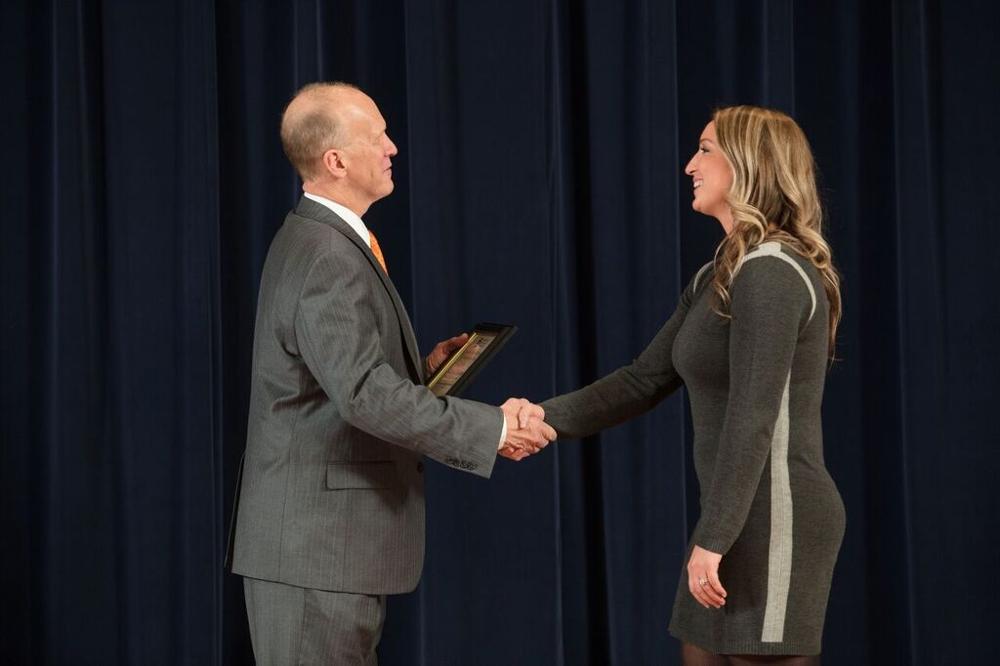 Doctor Potteiger shaking hands with an award recipient in a grey dress